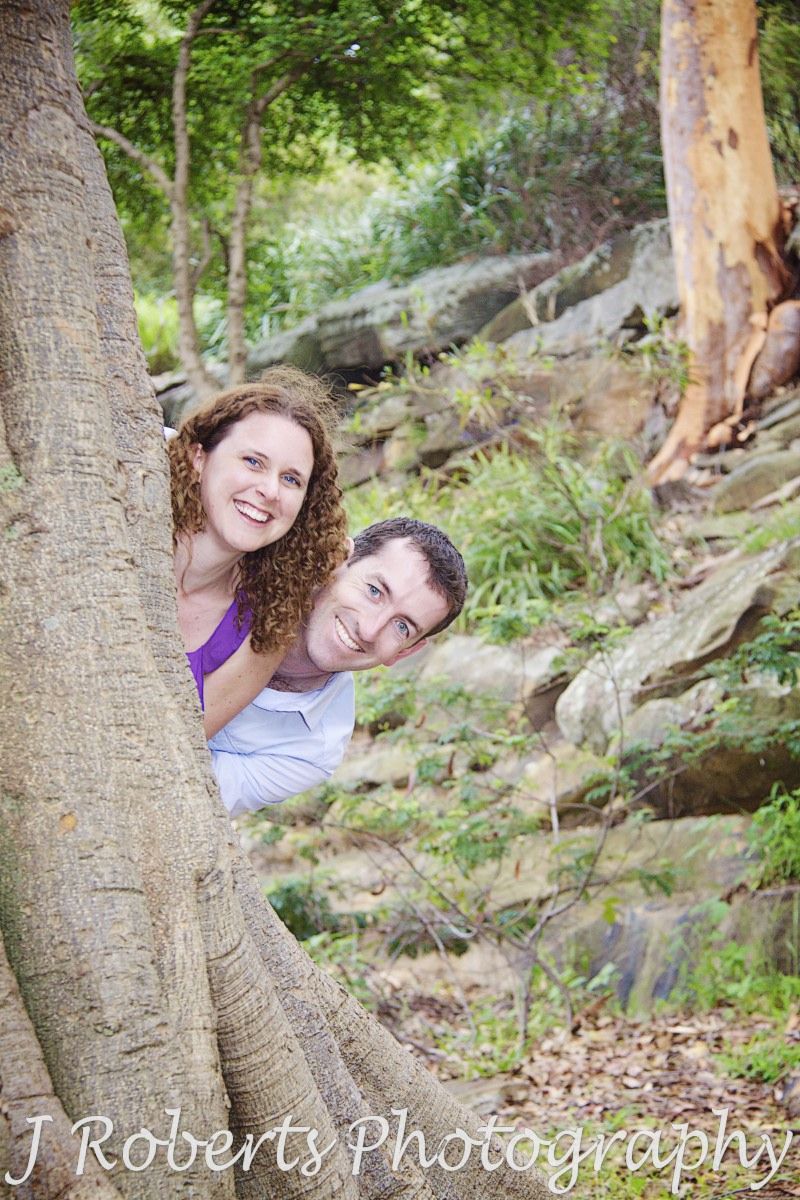 Peek-a-boo couple around a tree in the Royal Botanic Gardens Sydney - engagement photography sydney
